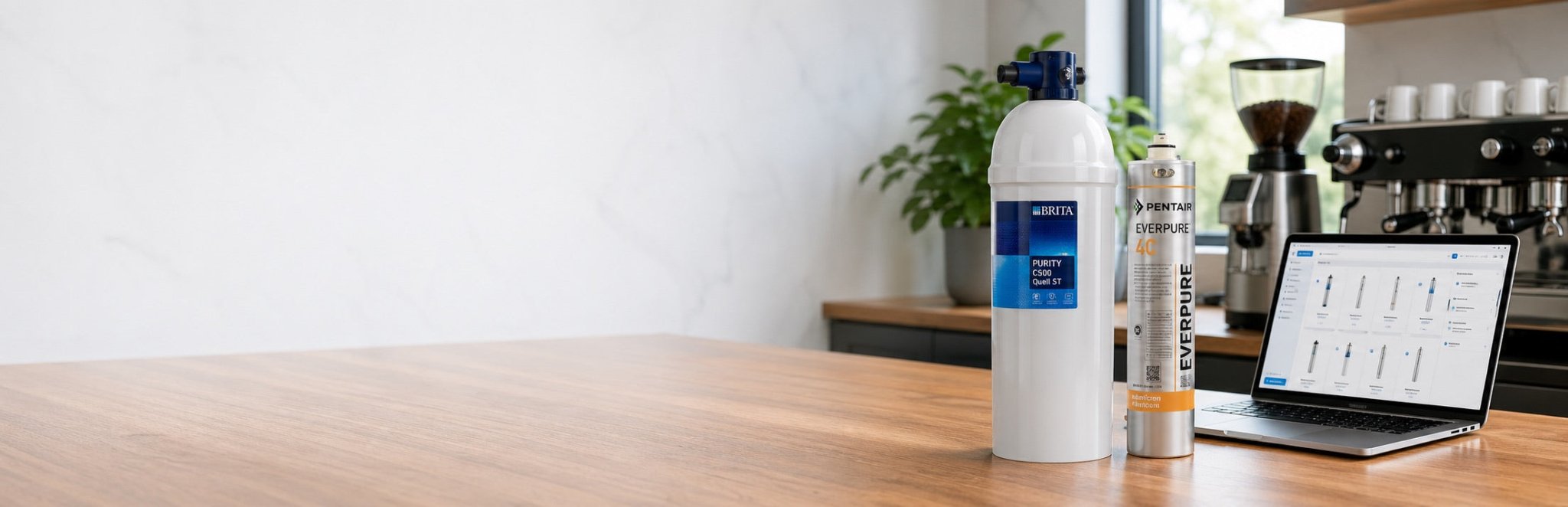Commercial water filter cartridges on a trade counter with ordering laptop